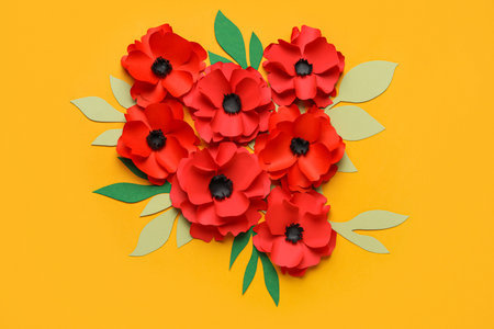 Paper poppy flowers with leaves on color backgroundの写真素材