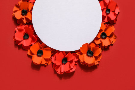 Blank paper sheet with poppy flowers on red backgroundの写真素材