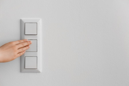 Woman switching on light at home, closeupの写真素材