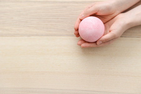 Woman with pink bath bomb on light wooden backgroundの写真素材