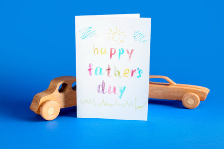 Greeting card for Father's Day and wooden cars on blue backgroundの写真素材