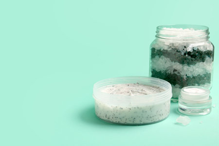 Jar of body scrub, cream and sea salt on color backgroundの写真素材
