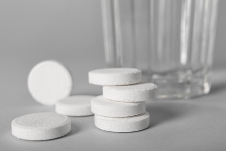 Soluble tablets and glass of water on gray backgroundの写真素材