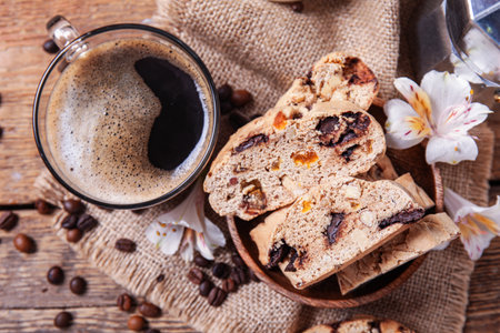 Delicious biscotti cookies, cup of coffee and coffee beans on wooden backgroundの写真素材