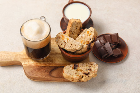 Delicious biscotti cookies, glass of coffee and cup of milk on white grunge backgroundの写真素材