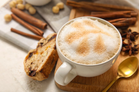 Board with cup of coffee and delicious biscotti cookie on white grunge background, closeupの写真素材