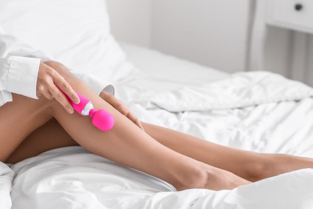 Young woman with pink vibrator in bedroom, closeupの写真素材