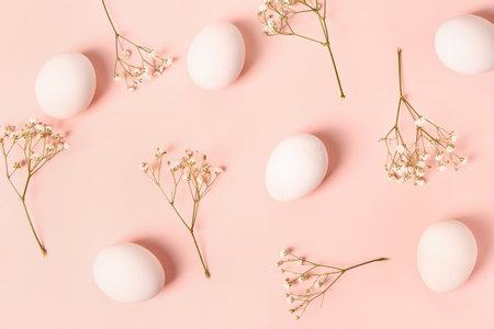 Composition with Easter eggs and gypsophila flowers on pink background