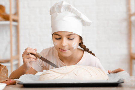 Little baker preparing dough for bread in kitchen, closeup