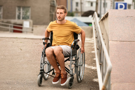 young man in wheelchair outdoorsの写真素材