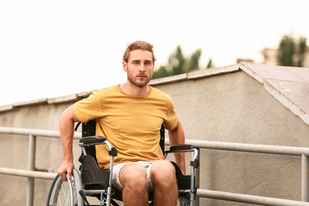 young man in wheelchair outdoorsの写真素材
