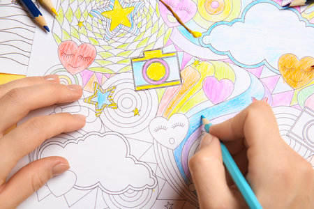 Woman coloring picture at table, closeupの写真素材