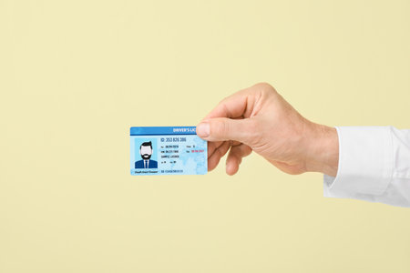Male hand with driving license on color backgroundの写真素材
