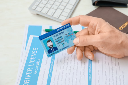 Man with driving license and application form at tableの写真素材