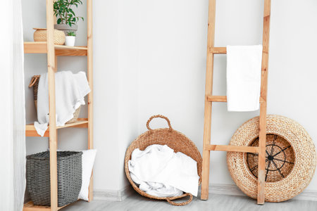 Rack and wicker baskets with towels in the roomの写真素材