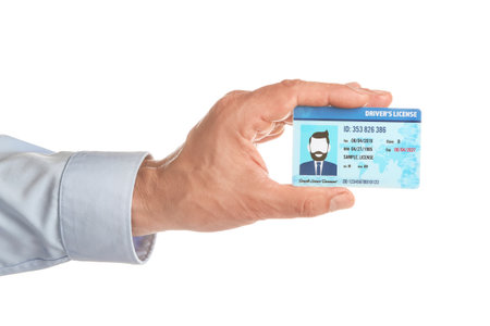 Male hand with driving license on white backgroundの写真素材
