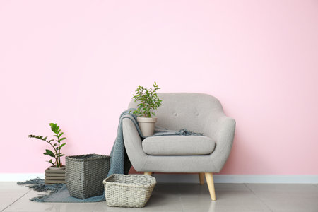 Armchair and wicker baskets with houseplants in roomの写真素材