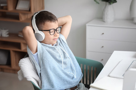 Cute little boy listening to music at home