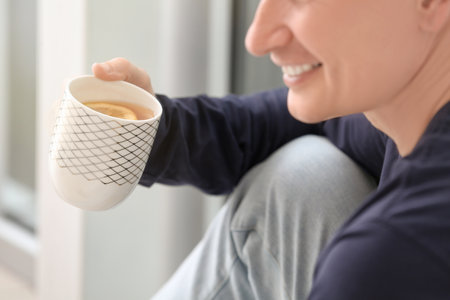 Handsome man drinking tea near window, closeupの写真素材