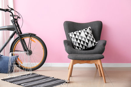Stylish armchair and ottoman with bicycle in interior of roomの写真素材