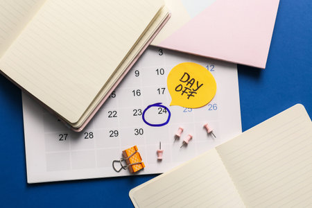 Stationery and calendar with text DAY OFF on color background
