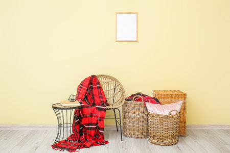 Wicker furniture and baskets with plaid near color wallの写真素材