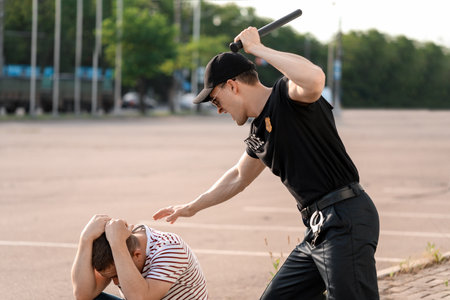 Aggressive police officer mistreating man outdoorsの写真素材