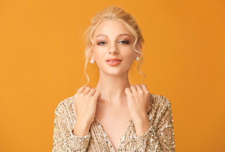 Beautiful young woman with stylish hairdo on color backgroundの写真素材