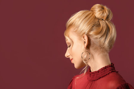 Beautiful young woman with stylish hairdo on color backgroundの写真素材