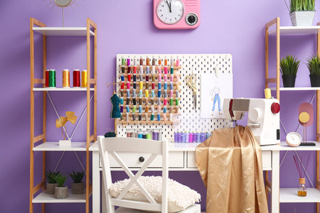 Interior of atelier with tailor's workplace, thread spools and shelving unitsの写真素材