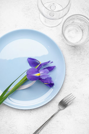Table setting with beautiful iris flower on gray grunge backgroundの写真素材