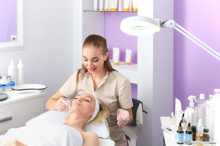 Woman undergoing cosmetic procedure in beauty salonの写真素材