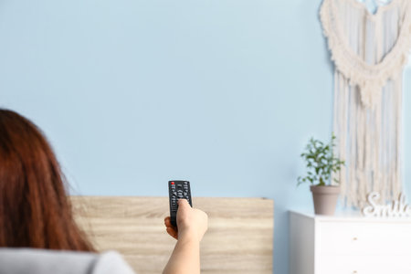 Young woman watching TV at homeの写真素材