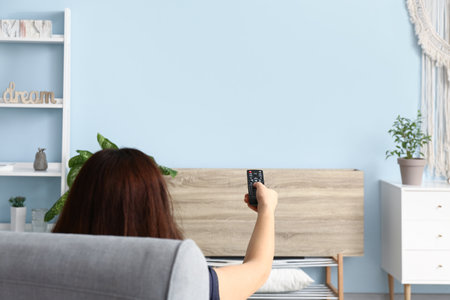 Young woman watching TV at homeの写真素材