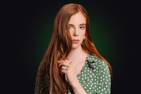 Beautiful young redhead woman on dark backgroundの写真素材