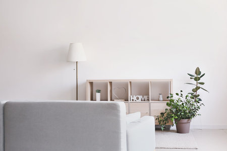 Wooden stand and lamp near light wall in room