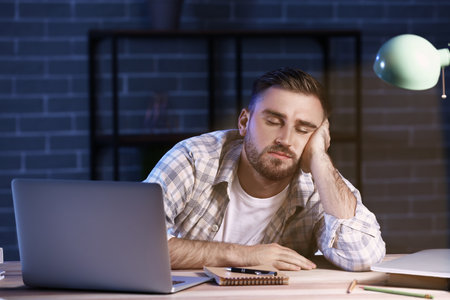 student sleeping at table late in the eveningの写真素材