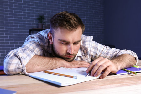 student sleeping at table late in the evening