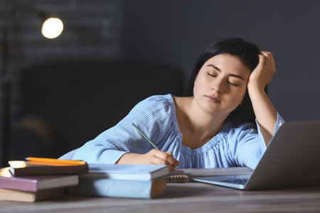 student sleeping at table late in the eveningの写真素材