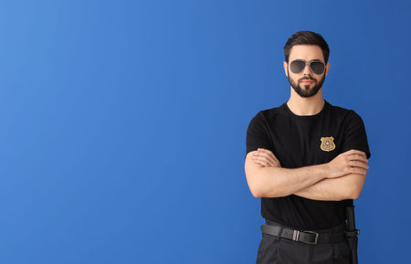 Handsome policeman on color background