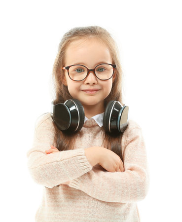Cute little girl with headphones on white backgroundの写真素材
