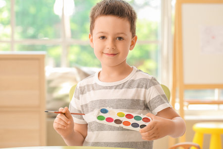 Cute little boy coloring pictures at homeの写真素材