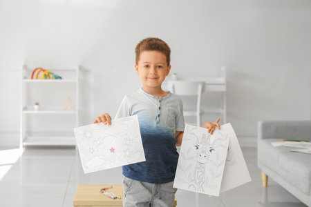 Cute little boy coloring pictures at homeの写真素材