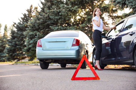Emergency stop sign near broken cars after accident on roadの写真素材