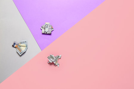 Origami figures made of dollar banknotes on color backgroundの写真素材