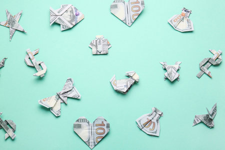 Origami figures made of dollar banknotes on color backgroundの写真素材