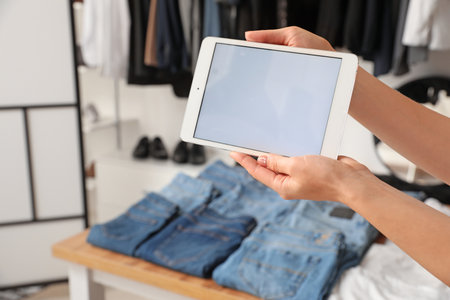 Woman with tablet computer in modern clothes storeの写真素材
