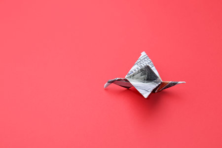 Origami bird made of dollar banknote on color backgroundの写真素材