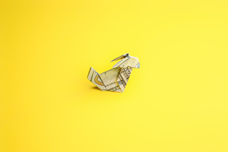 Origami rabbit made of dollar banknote on color backgroundの写真素材