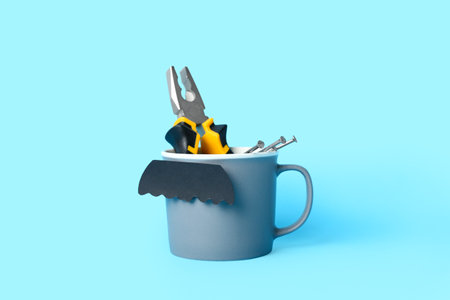 Cup with paper mustache, pliers and nails on blue background. father's day celebrationの写真素材